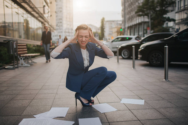 Overworked business woman having a lot of paperwork. Business woman surrounded by lots of papers. Business woman standing in the heap of papers. - Zdjęcie, obraz