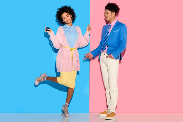 Mladý pár se baví na růžové a modré pozadí - Fotografie, Obrázek