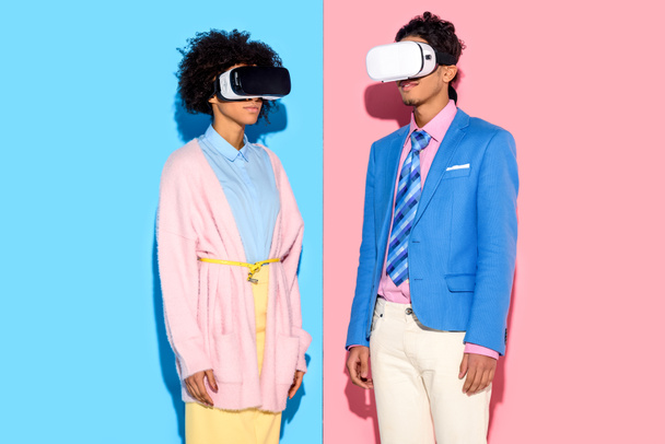 afro-amerikai házaspár vr fejhallgatók, rózsaszín és kék háttérrel portréja - Fotó, kép