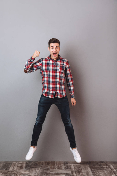 Full-length image of Screaming Cheerful man in shirt and jeans - Photo, Image