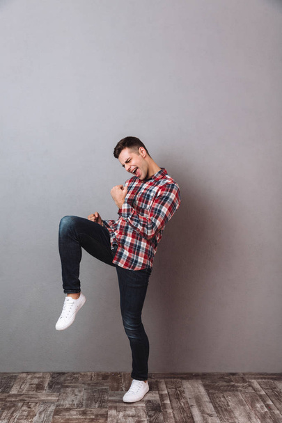 Full-length image of Screaming happy man in shirt and jeans - Fotó, kép