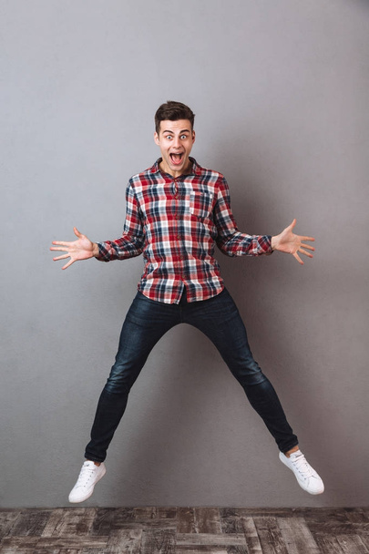Full-length image of Shocked screaming man in shirt and jeans - Foto, Bild