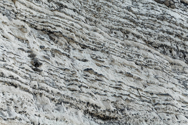 Στρώματα από σκουρόχρωμο βότσαλο σε ασβεστόλιθο της Κρητιδικής εποχής, στη Νορμανδία, στη Γαλλία. - Φωτογραφία, εικόνα