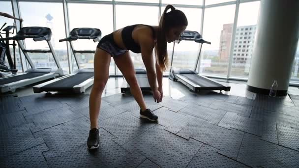 νεαρή γυναίκα να κάνει τις ασκήσεις στο γυμναστήριο - Πλάνα, βίντεο