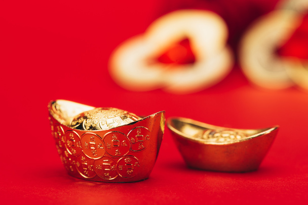 lähikuva laukaus kiinalainen kultainen harkot punaisella pinnalla
 - Valokuva, kuva