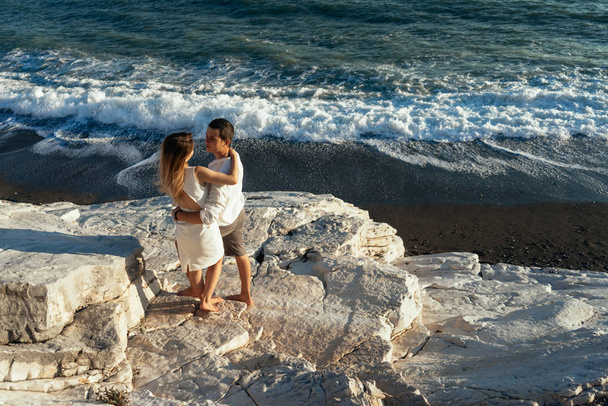 young couple hugging on the rocky seashore, summer - Photo, Image