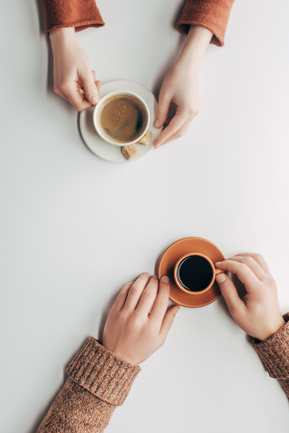 szemközti nézet férfi és női kéz csésze kávé a fehér - Fotó, kép