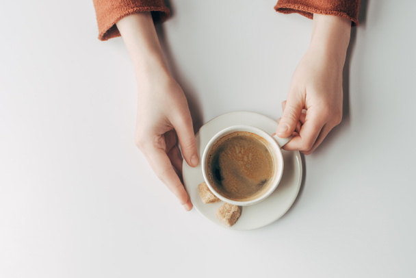 rajattu näkymä ihmisen kädet ja kuppi kahvia harmaa
  - Valokuva, kuva