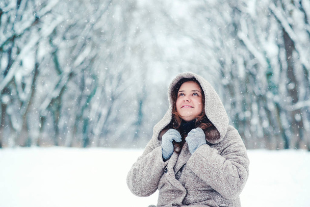 Egy parkban egy Hull a hó a téli nap, boldog fiatal nő portréja. - Fotó, kép