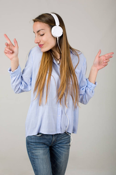 Красива молода жінка слухає музику з навушниками
 - Фото, зображення