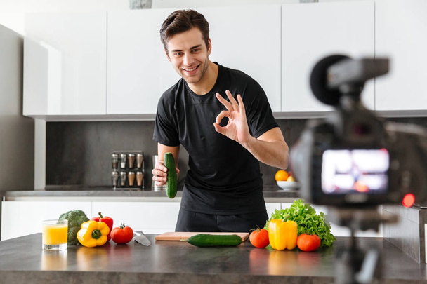 Smiling young man filming his video blog episode - Fotografie, Obrázek
