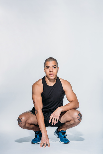 sportive african american squatting and looking at camera - Photo, Image