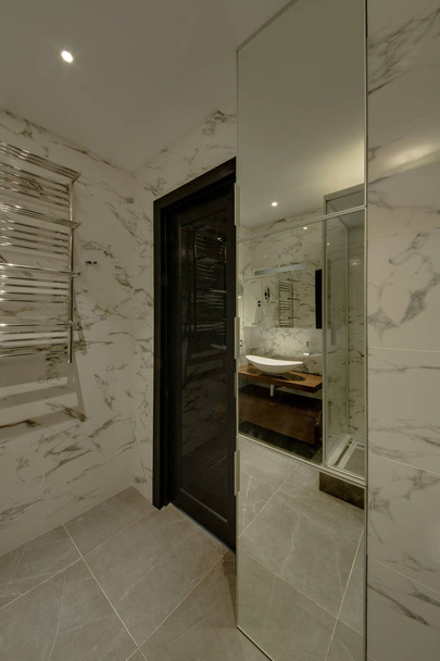 A bathroom with a big mirror in a floor and marble walls - Fotografie, Obrázek