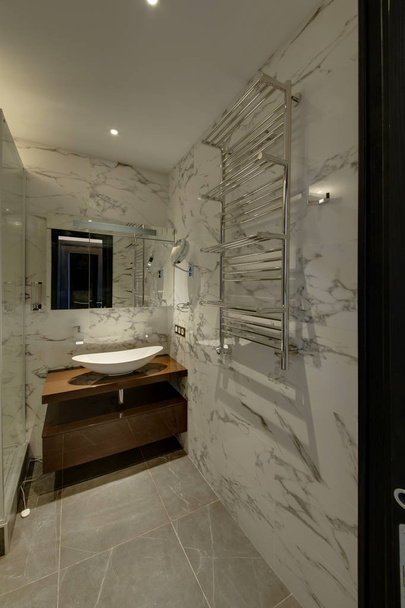 A bathroom with the suspended sink and the wide heated towel rail - Photo, Image