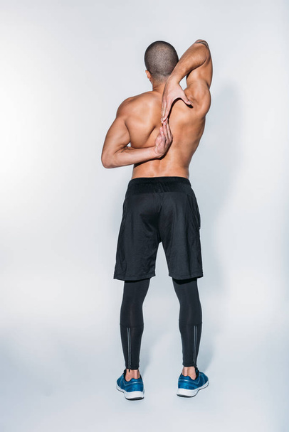 rear view of african american sportsman stretching back - Foto, Bild