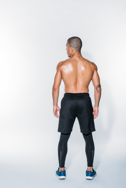 rear view of sweaty african american sportsman standing on white - Photo, Image