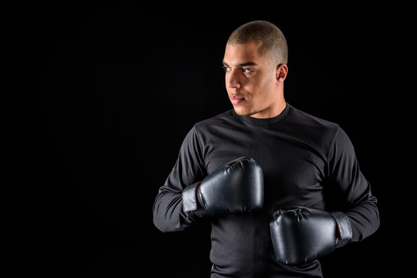 młody Afryki amerykański bokser w sprawny i czarne rękawiczki na czarnym tle - Zdjęcie, obraz