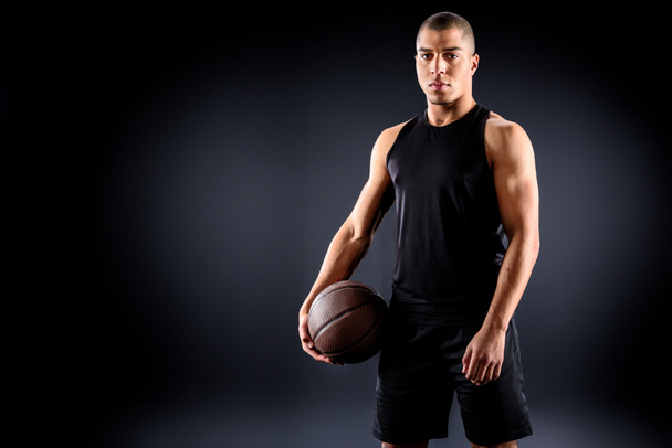 young african american basketball player with ball on black - Photo, image