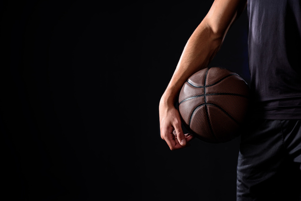 cropped shot of basketball player with ball isolated on black - Photo, Image