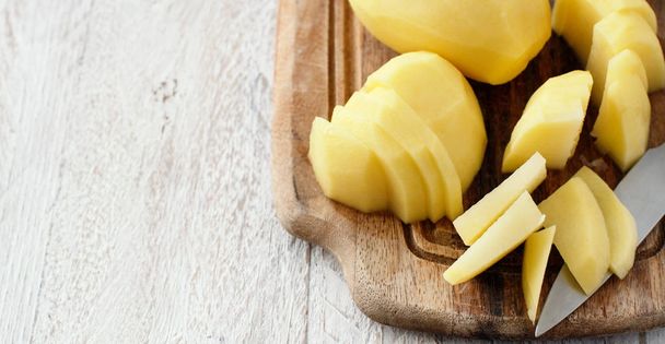 Raw peeled potatoes with a knife - Фото, изображение