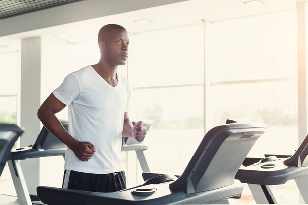 Young man in gym run on treadmill - Photo, Image
