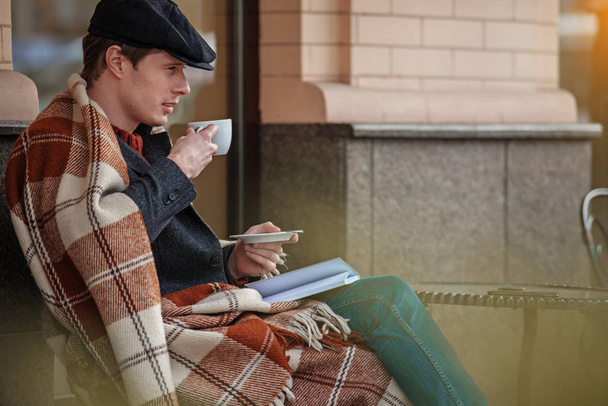 Attractive man drinking hot coffee while resting - 写真・画像