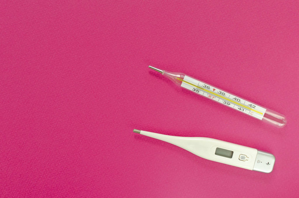 Quecksilber und digitale Thermometer auf rosa Hintergrund - Foto, Bild