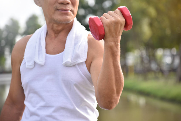 Asian Senior man lifting dumbbell. - Foto, Imagen