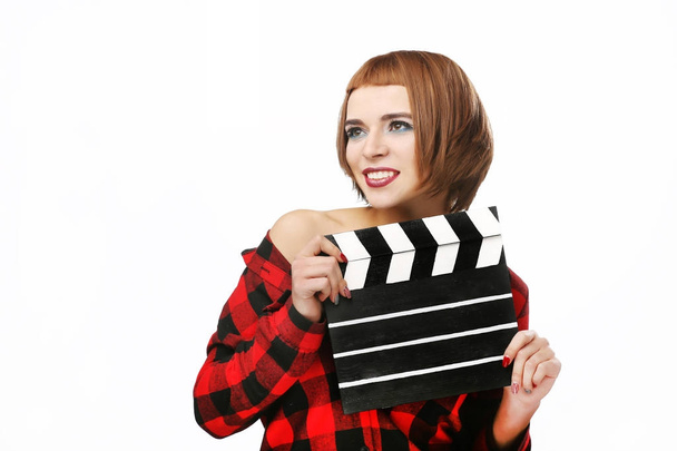 Beautiful young woman with cinema clapper posing in studio. Movi - Photo, Image