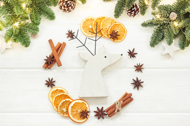 Christmas composition on a white background of Christmas decorations. Tree branches, cones, cinnamon sticks, star anise, dried oranges. Top view, flat lay - 写真・画像