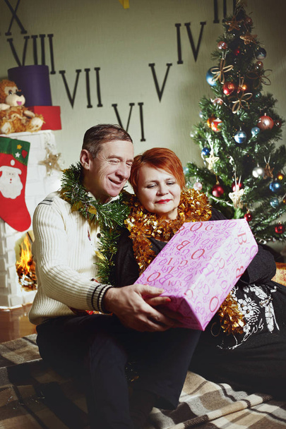 うれしそうな女性とクリスマス ツリーのそばに座って男 - 写真・画像