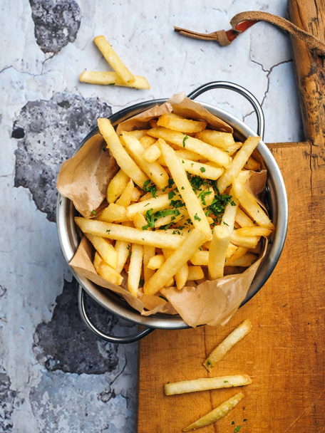 French fries on wooden board on rustic table - Foto, Imagen