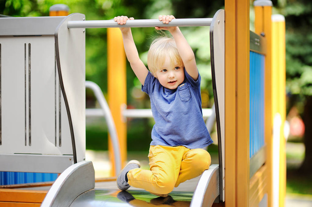 Little boy having fun on outdoor playground/on slide - Photo, Image