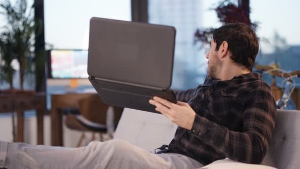 4K casual man relaxing at home having video chat and showing his apartment with laptop computer - Video