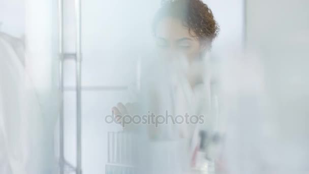 4K Research scientist working in laboratory, looking at sample under microscope. - Felvétel, videó