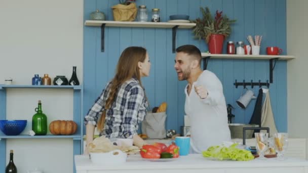 Slowmotion of Cheerful and attractive young couple in love dancing together rocknroll dance in the kitchen at home on holidays - Záběry, video
