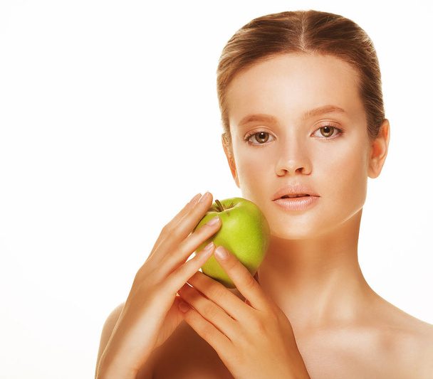 Head shot of woman holding green apple against white background - Photo, Image