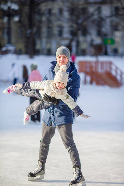 Famiglia di padre e figlio che si divertono sulla pista di pattinaggio all'aperto
 - Foto, immagini