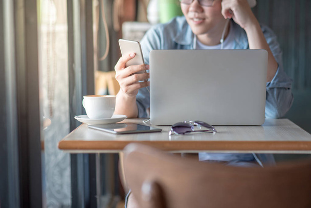 Fiatal ázsiai vállalkozó férfi smartphone és a laptop a kávézóban - Fotó, kép