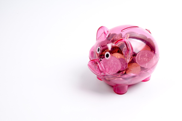 Coins in the red piggy bank isolated on white. Saving and investment conceptual. - Foto, Imagen