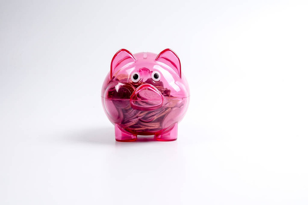 Coins in the red piggy bank isolated on white. Saving and investment conceptual. - Photo, Image