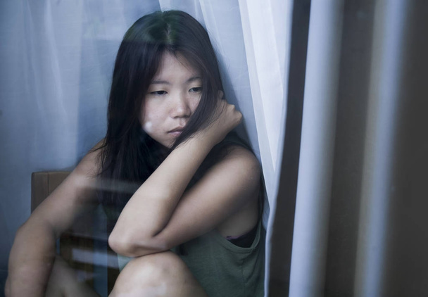fiatal szomorú és depressziós ázsiai kínai nő keres átgondolt keresztül ablaküveg szenvedés, fájdalom és a depresszió szomorúság koncepció - Fotó, kép