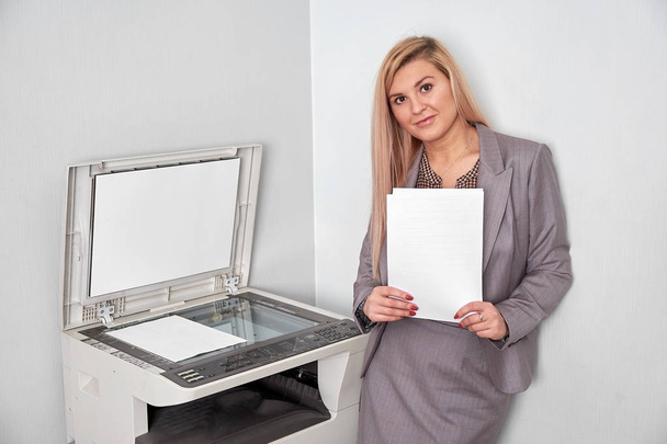 Geschäftsfrau arbeitet im Büro an einem Kopiergerät - Foto, Bild