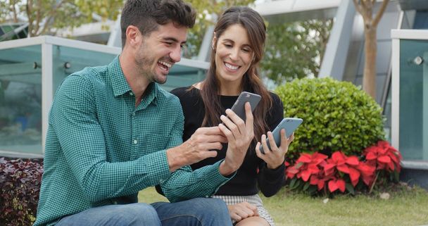 Caucasian woman and man using cellphone together  - Foto, afbeelding