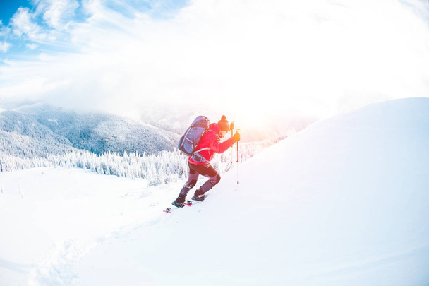 Un homme en raquettes dans les montagnes en hiver
.  - Photo, image