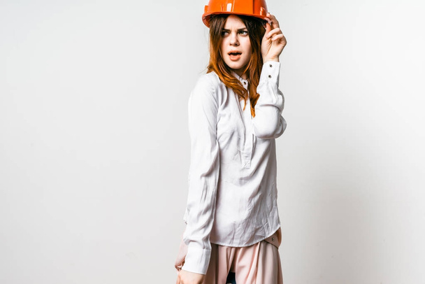 young girl in an orange helmet on a gray background - Photo, image