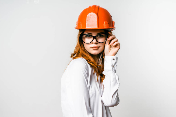 young girl in orange construction helmet on white background - Foto, imagen
