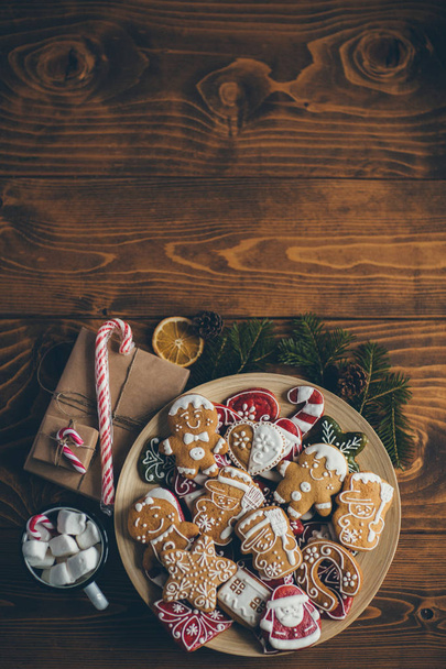  Christmas cookies on wooden table with cup of hot chocolate and gifts - Фото, зображення