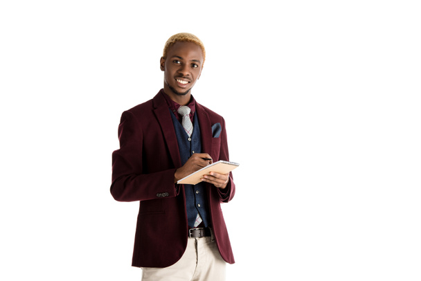 sorridente afro-americano homem segurando notepan e caneta em mãos isoladas em branco
 - Foto, Imagem