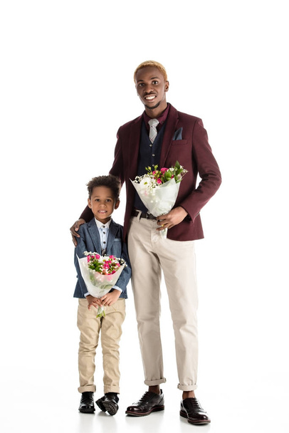 Yong african man and kid standing with flowers in hands isolated on white - Photo, Image